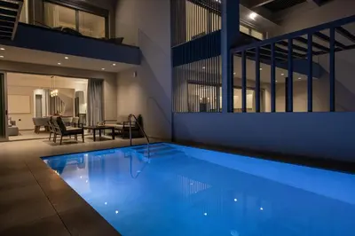 a large swimming pool in a house with a dining room at Punto De Vista Luxury Villas in Korakiaí