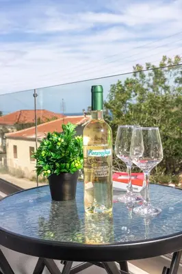 a bottle of wine sitting on a table with two wine glasses at Mariam Luxury Apartments in Chania Town