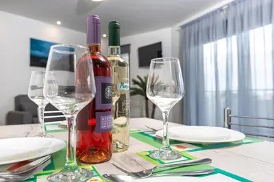 a table with wine bottles and glasses on it at Mariam Luxury Apartments in Chania Town
