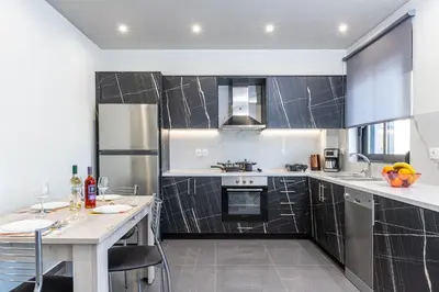 a kitchen with stainless steel appliances and black tiles at Mariam Luxury Apartments in Chania Town