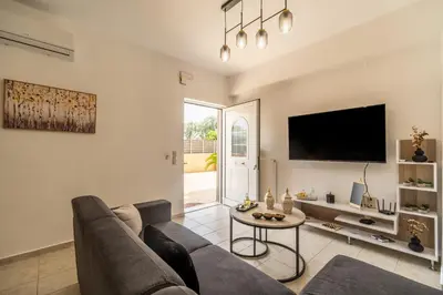 a living room with a couch and a tv at Ampelos in Perivólia