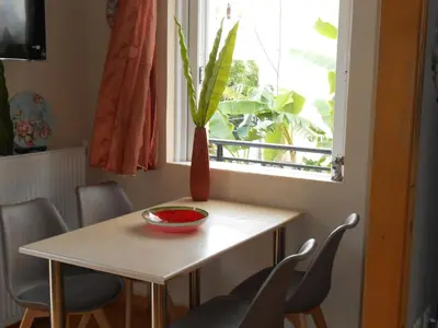 a table and chairs with a vase on it in front of a window at Banana Leaves Flat in Chania Town