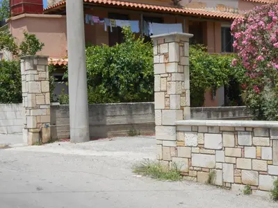 a house with a stone wall and flowers at Banana Leaves Flat in Chania Town