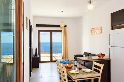 a kitchen and living room with a table and a kitchen and a dining room at Livaniana Panoramic View House 1 in Livanianá