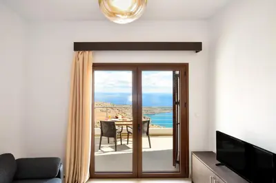 a living room with a sliding glass door leading to a table at Livaniana Panoramic View House 1 in Livanianá