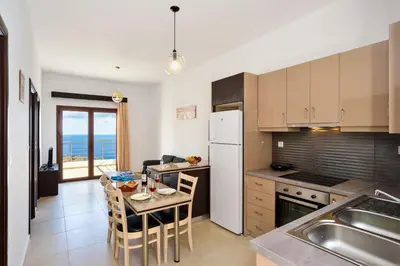 a kitchen with a table and a kitchen with the ocean at Livaniana Panoramic View House 1 in Livanianá