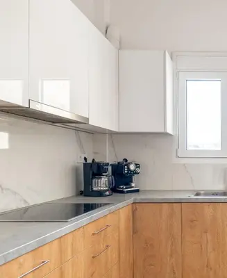 a kitchen with white cabinets and a counter top at Corso Venezia Luxury Apartment 3BR in Chania Town