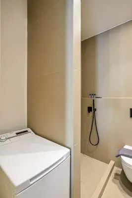 a small bathroom with a toilet and a shower at Alex Downtown Holiday Apartment in Chania Town