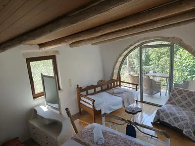 a living room with a bed and a tv at Kourtsa villas in Vafés