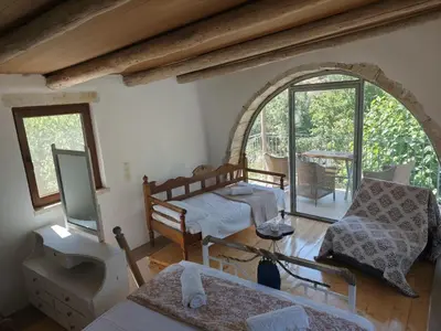 a living room with a bed and a tv at Kourtsa villas in Vafés