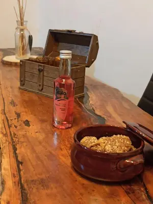 a bottle of alcohol sitting next to a bowl of food at Kourtsa villas in Vafés