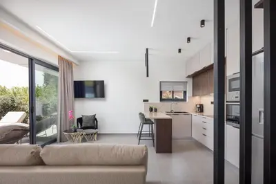 a living room with a couch and a kitchen at VillaSaints I Private Pool Villas, Walk to Beach, BBQ in Chania Town