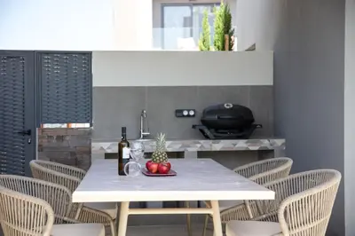 a white table with fruit and a bottle of wine at VillaSaints I Private Pool Villas, Walk to Beach, BBQ in Chania Town