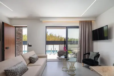 a living room with a couch and a table at VillaSaints I Private Pool Villas, Walk to Beach, BBQ in Chania Town