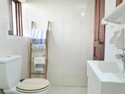 a white bathroom with a toilet and a sink at Liva apartments in Chania Town