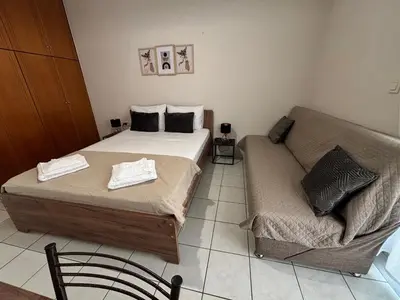 a bedroom with two beds and a couch at Lynne's Harmony Chania Beach Studio in Chania Town