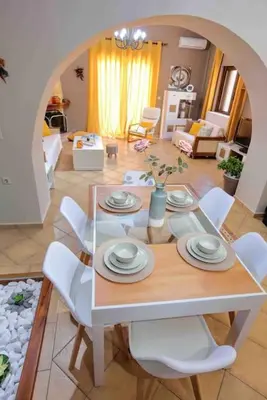 a dining table and chairs in a living room at VALENA COZY MAISONETTE (15 min-ELAFONISI BEACH) in Élos