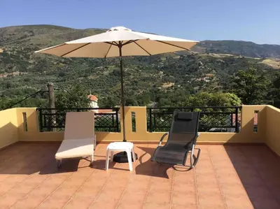 a patio with two chairs and an umbrella at VALENA COZY MAISONETTE (15 min-ELAFONISI BEACH) in Élos