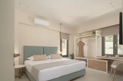 a white bedroom with a bed and a desk and a sink at Reflection Villa, Heated Pool & Absolute Seclusion, By ThinkVilla in Chania Town