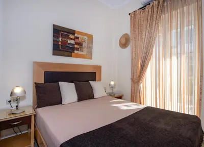 a bedroom with a large bed and a window at Socrates Holidays Apt. 1 with Pool near the Beach in Kamisianá