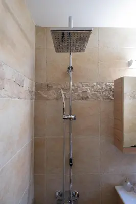a shower with a shower head in a bathroom at The Fabrica Falasarna in Plátanos