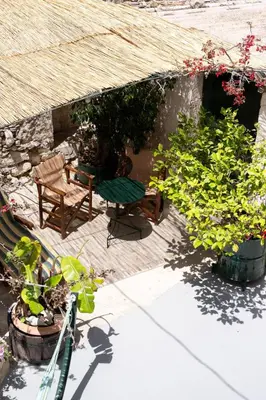 a patio with a table and chairs and plants at The Fabrica Falasarna in Plátanos