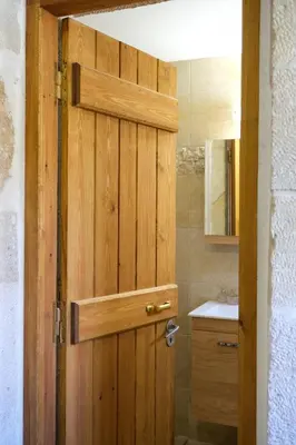 a wooden door in a bathroom with a sink at The Fabrica Falasarna in Plátanos