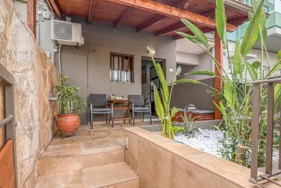 a patio with a table and some plants at Modern Studio 2 with a Yard in Chania Town