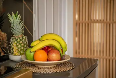 a bowl of fruit with bananas and apples on a counter at Modern Studio 2 with a Yard in Chania Town
