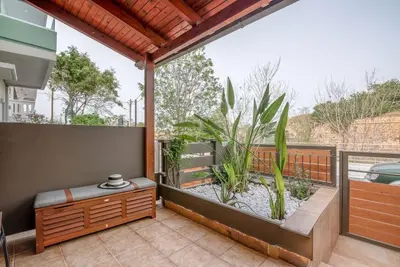 an outdoor patio with a bench and a plant at Modern Studio 2 with a Yard in Chania Town