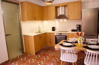 a kitchen with a table and chairs and a refrigerator at Dimitriοs Stone House in Chania Town