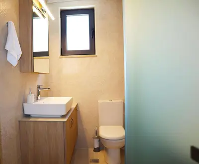 a bathroom with a sink and a toilet and a window at Dimitriοs Stone House in Chania Town