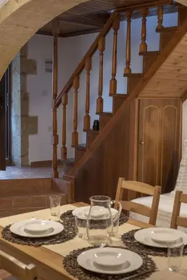 a table with plates and glasses on top of it at Skaros Cottage in Chania Town