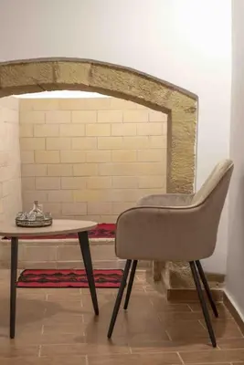 a chair sitting next to a table in a room at Skaros Cottage in Chania Town