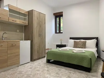 a bedroom with a large bed with a green blanket at Skaros Cottage in Chania Town