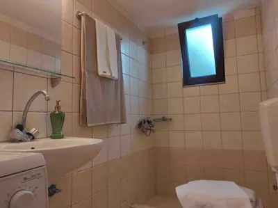 a bathroom with a sink and a toilet and a window at Skaros Cottage in Chania Town