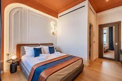 a bedroom with a large bed with blue pillows at MiraVita Boutique Hotel - Adults Only in Chania Town