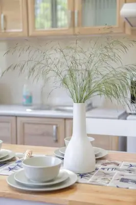 a white vase with plants in it on a table at VALENA STYLISH HOME (15 min TO ELAFONISI BEACH) in Élos