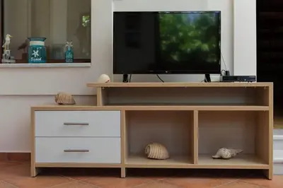 a wooden entertainment center with a flat screen tv at VALENA STYLISH HOME (15 min TO ELAFONISI BEACH) in Élos