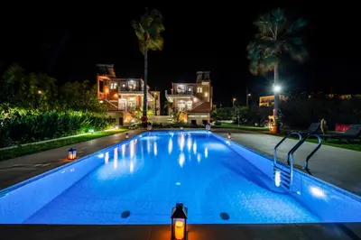a swimming pool at night with a house in the background at Socrates Holidays Apt. 2 with Pool near the Beach in Plataniás