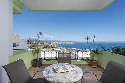 a balcony with a table and chairs and the ocean at Mystique Sunset View in Chania Town