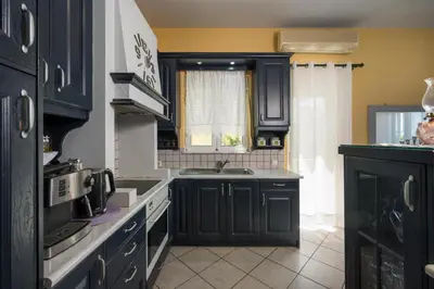 a kitchen with black cabinets and a sink at Mystique Sunset View in Chania Town