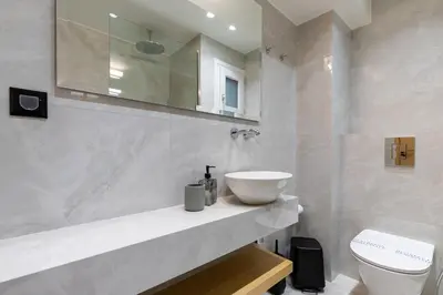 a white bathroom with a sink and a toilet at CRETA ELENA SUITE in Chania Town