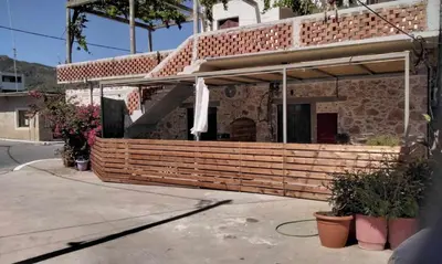 a brick house with awning and plants in front of it at Elaion Apartments in Kántanos