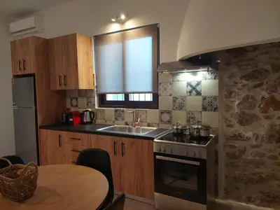 a kitchen with a sink and a stove and a table at Elaion Apartments in Kántanos