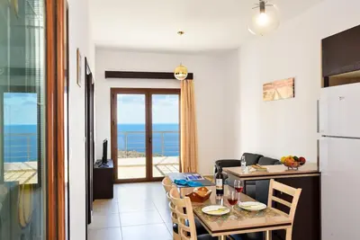 a kitchen and dining room with a table and a refrigerator at Livaniana Panoramic View house 2 in Livanianá
