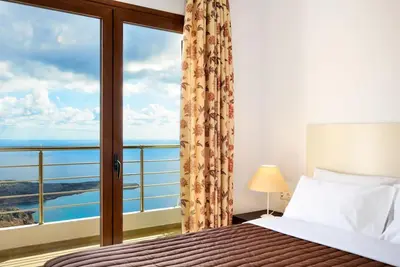 a bedroom with a bed with a view of the ocean at Livaniana Panoramic View house 2 in Livanianá