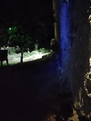 a dark room with a bench and a tree at night at Liza's Place in Metókhion