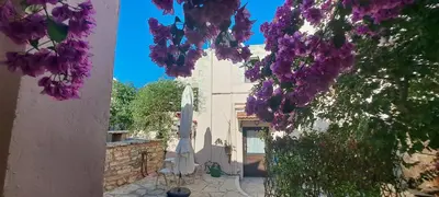 a building with purple flowers and an umbrella at Villa ABBA in Plaka