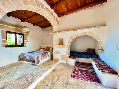 a room with two beds and a stone wall at Villa ABBA in Plaka
